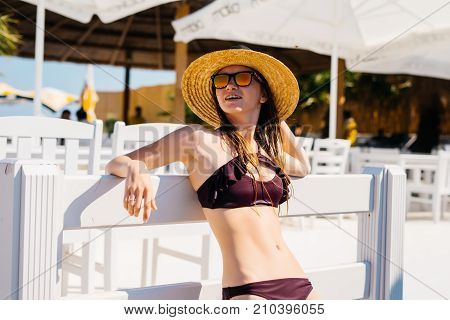 Rich lifestyle woman relaxing enjoying luxury beach hotel,palms and umbrella around,expensive resort,summer vacations