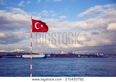 Turkish flag with Bosphorus straight on background. Blue sky. Boats on background