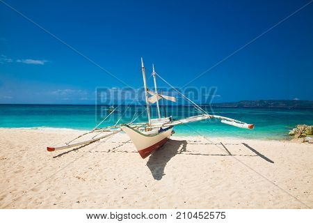 Traditional boat on shore at Puka beach. Boracay island. Philippines.