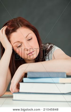 Jeune étudiant Fallling endormi avec son avant-bras sur ses livres