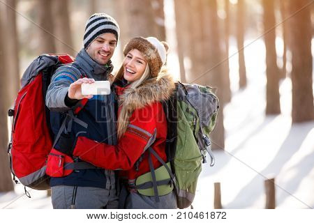 Young couple taking selfie in forest