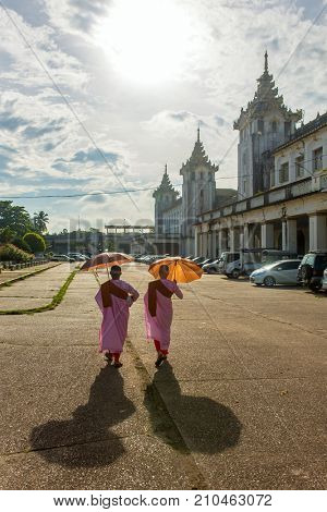 Yangon, Myanmar - September 29, 2016: Yangon street scene: Buddhist nuns walk near by Yangon central railway station in Burma.