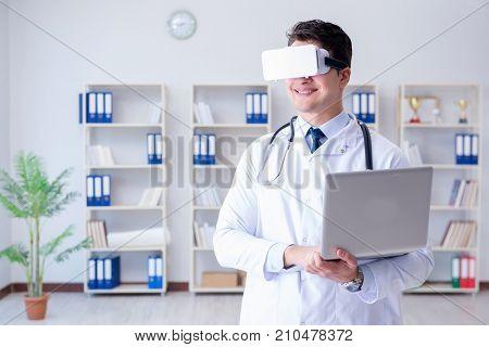 Young doctor with vr virtual reality headset working in the offi