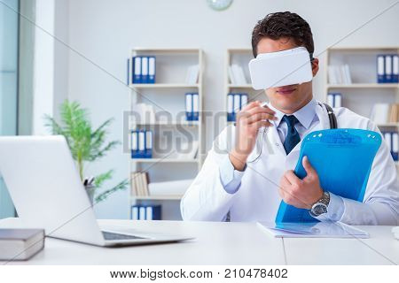 Young doctor with vr virtual reality headset working in the offi