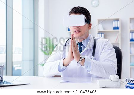 Young doctor with vr virtual reality headset working in the offi