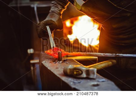 Blacksmith working on metal on anvil at forge high speed detail shot