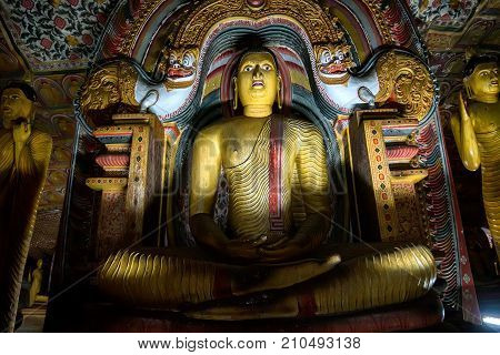 Meditating Buddha under makara torana in Maha Aluth Viharaya at buddhists cave temple in Dambulla, Sri Lanka. 