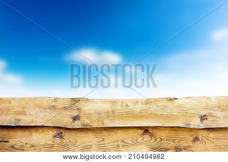 Wooden fence against blue sky with clouds background