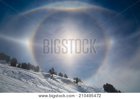 Sun halo arcs over winter landscape. Rare natural phenomenon