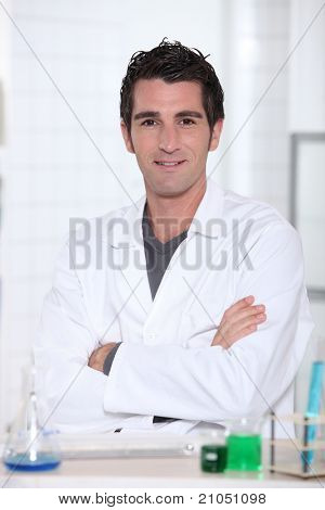 Muž nosí laboratorní plášť