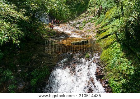 Tourists Crossing Rapid Mountain River In Golden Stream Ecotourism Area,park In Vietnam