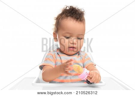 Cute little African American baby with nibbler on white background