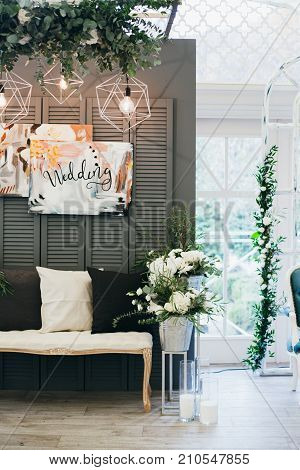 Wedding decorations with flowers in Boho style indoors. Large windows on background. DIY