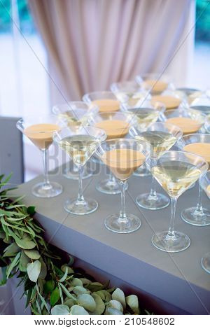 Wedding decorated stylish alcohol bar. With some euqaliptus and big windows on background