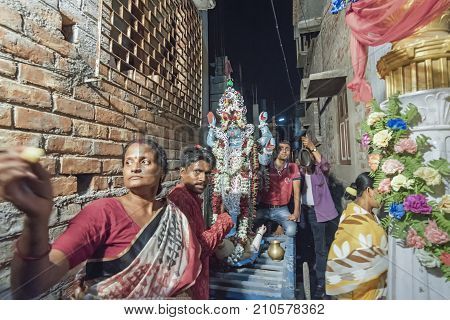 KOLKATA INDIA - JUNE 17 2017 - Female Hindu devotees worshipping Goddess Kali at night during Kali Puja Hindu festival of Deepavali or Diwali. Celebtated all over India. Shot under mixed light.