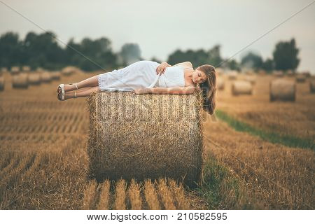 Beautiful Girl On Hay Bales In The Fields