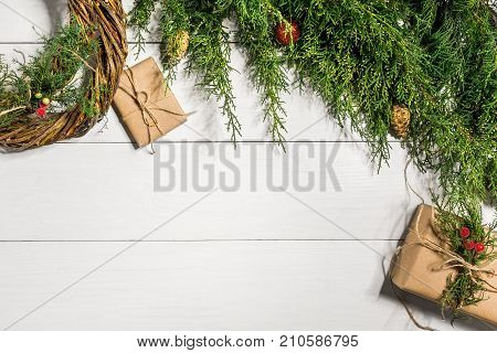 Make a Christmas wreath with your own hands. Spruce branch, Christmas wreath and gifts on a white wooden background. Workplace for preparing handmade decorations. Christmas and New year