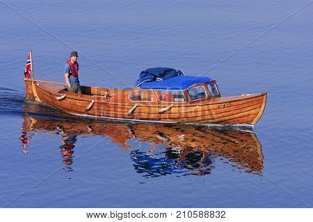 KRISTIANSAND ARCHIPELAGO, NORWAY ON JULY 02. Professional working man in a minor wooden boat heading for the sea on July 02, 2009 in Kristiansand, Norway. Unidentified man. Editorial use.