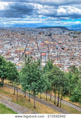 High view of Quito, from the Panecillo hill, on a cloudy and overcast afternoon. Quito, Ecuador.