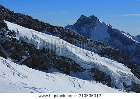 View from Jungfraujoch Switzerland. Glacier with big crevasses and high mountain.