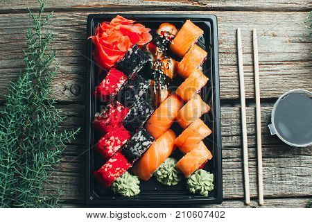 On A Wooden Table Lay In The Black Sushi Container
