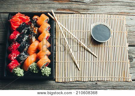 On A Wooden Table In The Black Container Are Nicely Decomposition Sushi