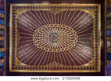 Cairo, Egypt - October 21, 2017: Wooden golden ornate ceiling with design based on sun rays inspired by the old flag of the ottoman empire at the public mosque of The Manial Palace of Prince Mohammed Ali Tewfik
