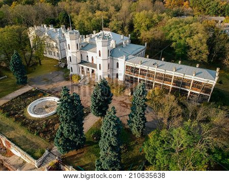 Aerial view on abandoned ruined castle and park. Autumn color image in sunset light.