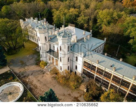 Aerial view on abandoned ruined castle and park. Autumn color image in sunset light.