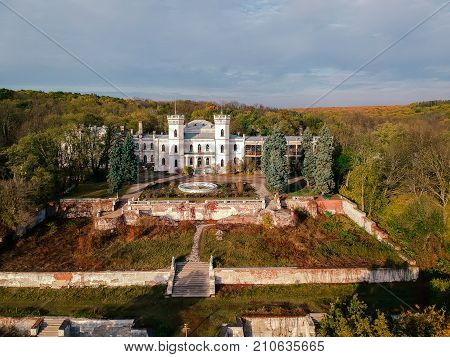 Aerial view on abandoned ruined castle and park. Autumn color image in sunset light.