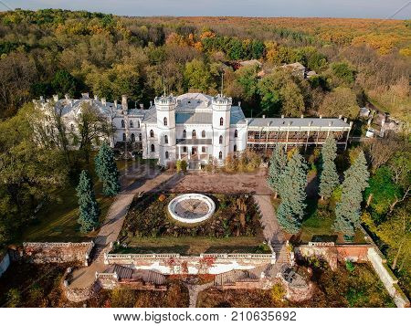 Aerial view on abandoned ruined castle and park. Autumn color image in sunset light.