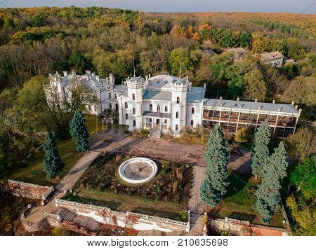 Aerial view on abandoned ruined castle and park. Autumn color image in sunset light.