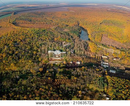 Aerial view on abandoned ruined castle and park. Autumn color image in sunset light.
