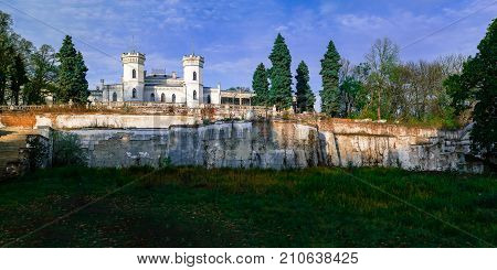 View on abandoned ruined castle and park. Autumn color image in sunset light.