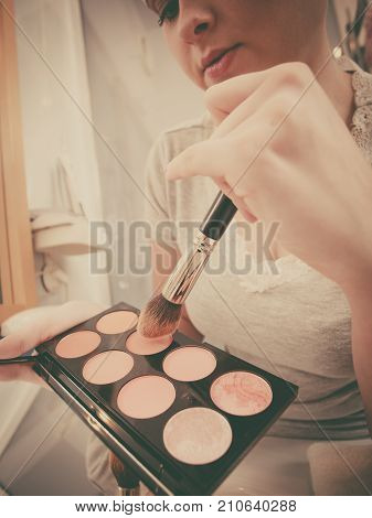 Woman In Bathroom Applying Contour Bronzer On Brush