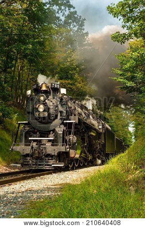 PENINSULA OH - SEPTEMBER 17 2917: The NKP-765 one of the largest steam locomotives still in existence emerges from a narrow pass through woods south of Cleveland.