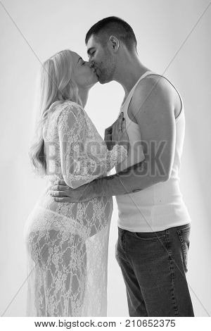 Beautiful pregnant couple in love on the background. Hands of husband on the tummy of his pregnant wife. Young man tenderly stroked pregnant belly of his wife. Husband kissing pregnant belly.
