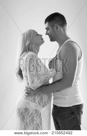 Beautiful pregnant couple in love on the background. Hands of husband on the tummy of his pregnant wife. Young man tenderly stroked pregnant belly of his wife. Husband kissing pregnant belly.
