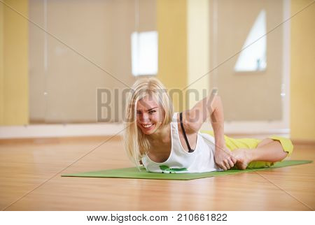 Beautiful sporty fit yogi woman practices yoga asana Bhekasana - frog pose in the yoga class