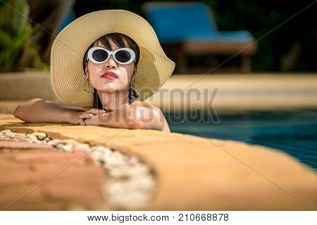 Women wearing bikini or swimware suits at swimming pool at the resort of Pattaya in Thailand.