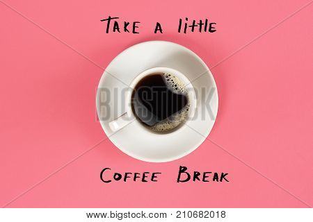Top view of cup of black coffee and Take a little coffee break lettering isolated on pink background. Still life. Mock up. Flat lay