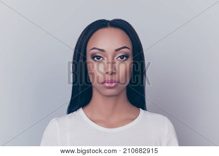 Close Up Portrait Of Young Brunette Afro Lady With Serious Grimace, On Pure Grey Backgrund And Looki
