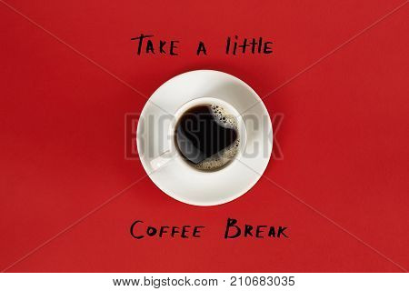 Top view of cup of black coffee and Take a little coffee break lettering isolated on red background. Still life. Mock up. Flat lay