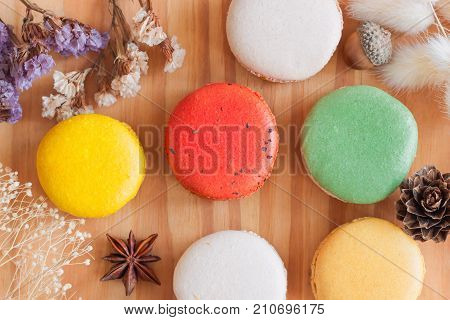 Beautiful and cute French macaron or Italian macaron in top view flat lay. Homemade delicious pastel color macaron on wood table for background or wallpaper. 