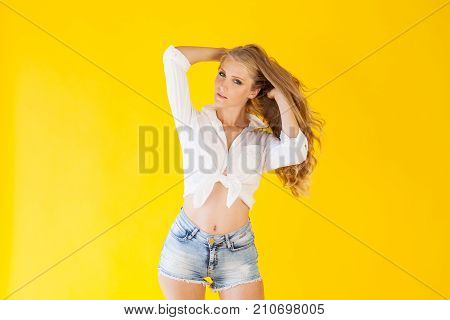 Beautiful Blonde With Blue Eyes Posing On A Yellow Background 1