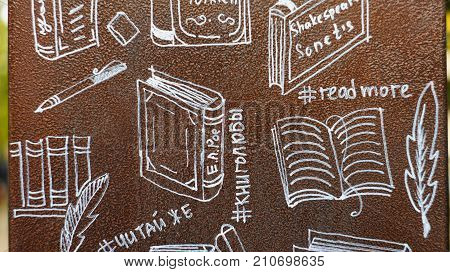 Figures book on the painted metal surface of the bookcase, which is located a park alley Nalchik. Anyone can take a book from the closet to read while walking in the park.