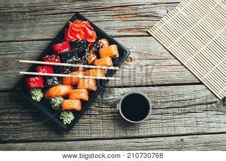 On A Wooden Table In The Black Container Are Nicely Decomposition Sushi