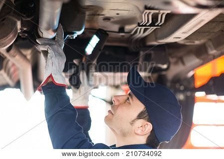 Portrait of a mechanic repairing a car in his garage