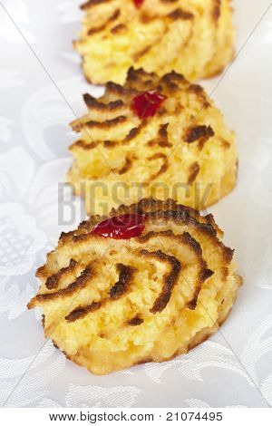 Kokosowe makaroniki zwieńczona glace wiśnie.  Skupić się na przód makaronik.