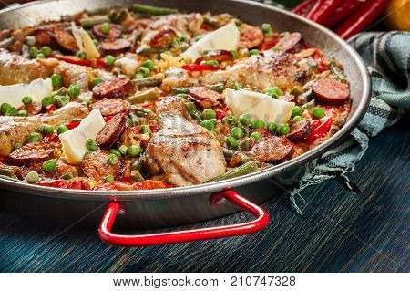 Traditional Paella With Chicken Legs, Sausage Chorizo And Vegetables Served In Paellera